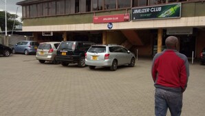 A building with a sign for 'JIMLIZER CLUB' and 'SOUND PROCESSORS'. There are several cars parked in front. - Jimlizer Hotel (Nairobi)