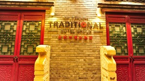A hotel facade with traditional Chinese architectural elements, including ornate doors and a brick wall. - Beijing Traditional View Hotel (Beijing)