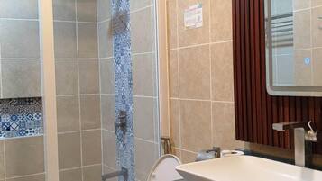 A bathroom with a shower, toilet, and sink.