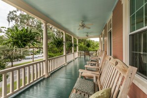 A covered porch with wooden chairs and a ceiling fan. - Spencer House Inn Bed & Breakfast (St. Marys)