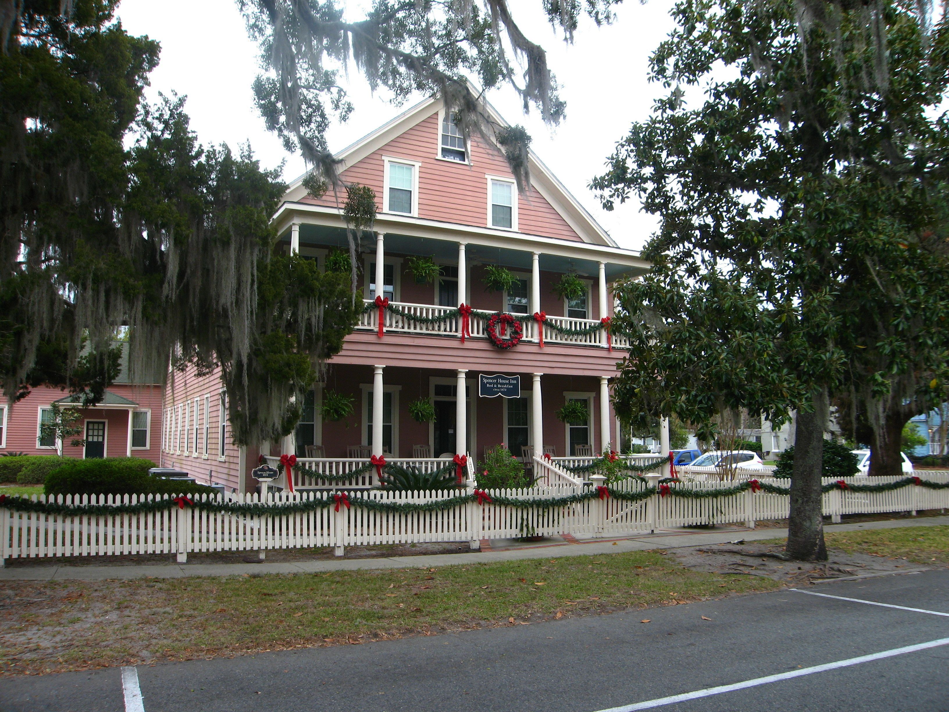 A two-story building with a balcony, decorated with Christmas garlands and wreaths.