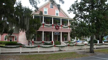 A two-story building with a balcony, decorated with Christmas garlands and wreaths.