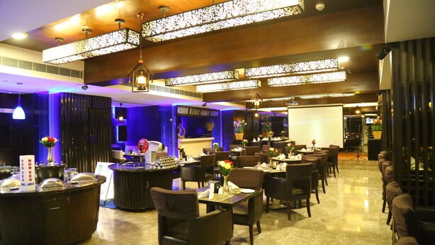 Restaurante com interior moderno, incluindo área de bar, diversas mesas de jantar e várias opções de assento.