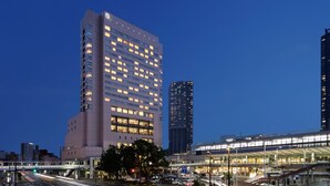 Un hotel moderno con varios pisos, una galería techada y una fachada bien iluminada.