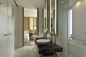 Un baño moderno con un lavamanos grande, dos espejos y una bañera.