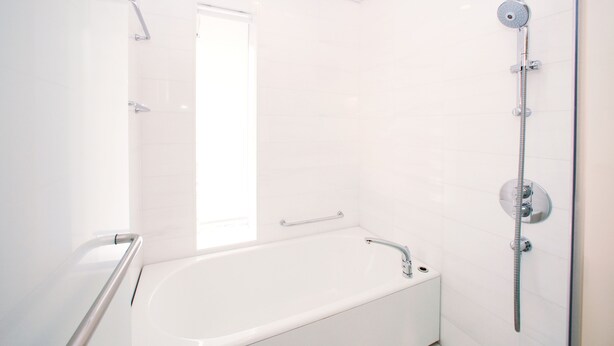 A modern bathroom with a white bathtub, a shower with a handheld showerhead, and a glass shower enclosure. - Sheraton Grand Hiroshima Hotel (Hiroshima)