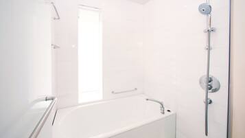 A modern bathroom with a white bathtub, a shower with a handheld showerhead, and a glass shower enclosure.