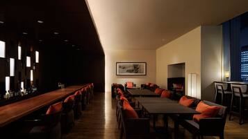 A modern conference room with a long table, multiple chairs, and a bar area.