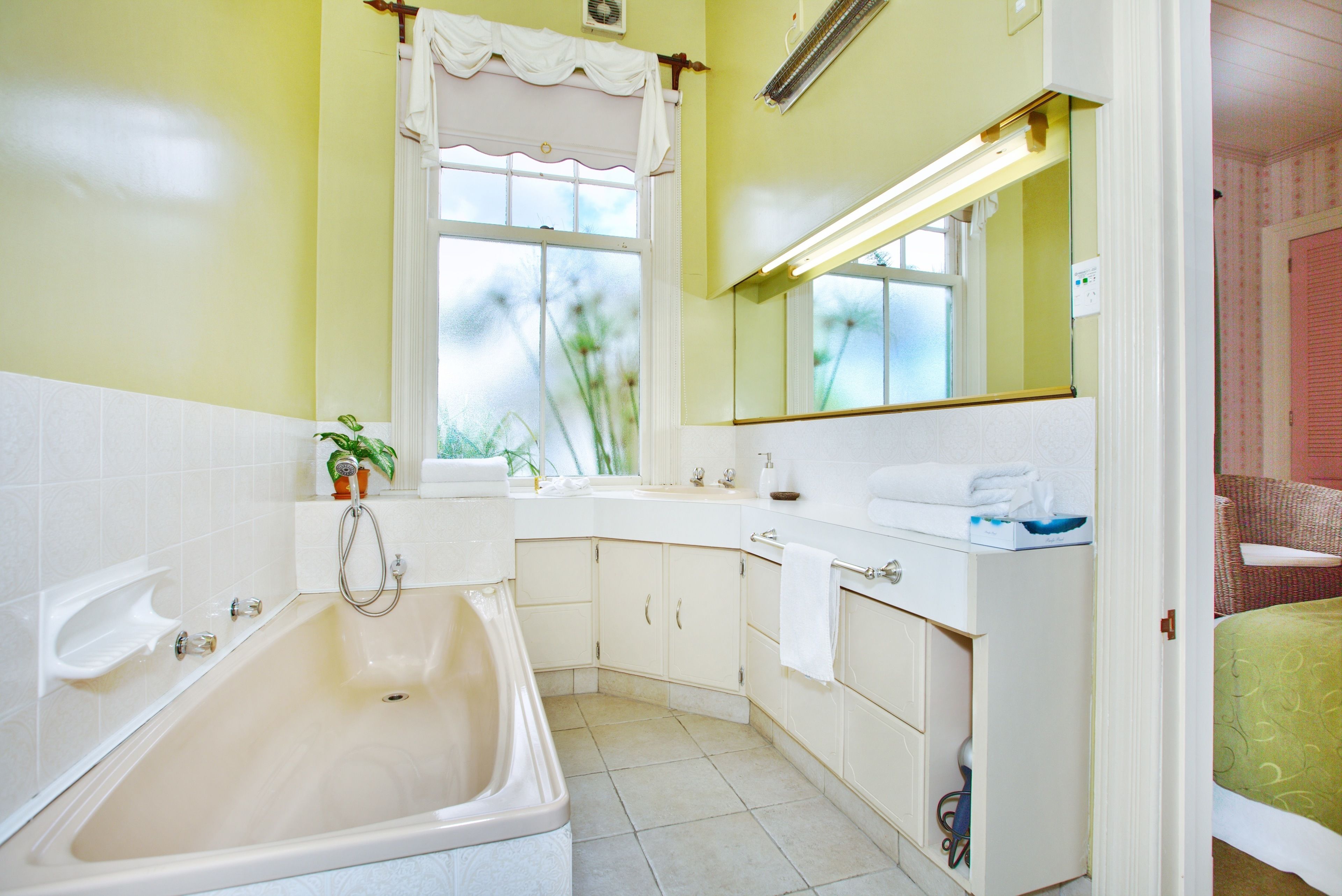 A bathroom with a bathtub, a sink, and a mirror.