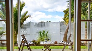 An outdoor patio with a white picket fence, two wooden chairs, and a small table. - Warkworth Lodge (Warkworth)