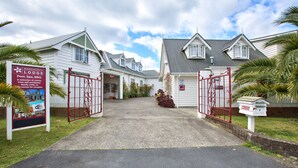 A gated entrance to a lodge with a signboard advertising a pool, spa, and BBQ. - Warkworth Lodge (Warkworth)
