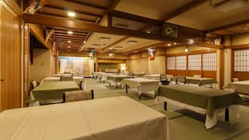 A traditional Japanese inn with multiple tatami mat rooms, wooden beams, and shoji screens.