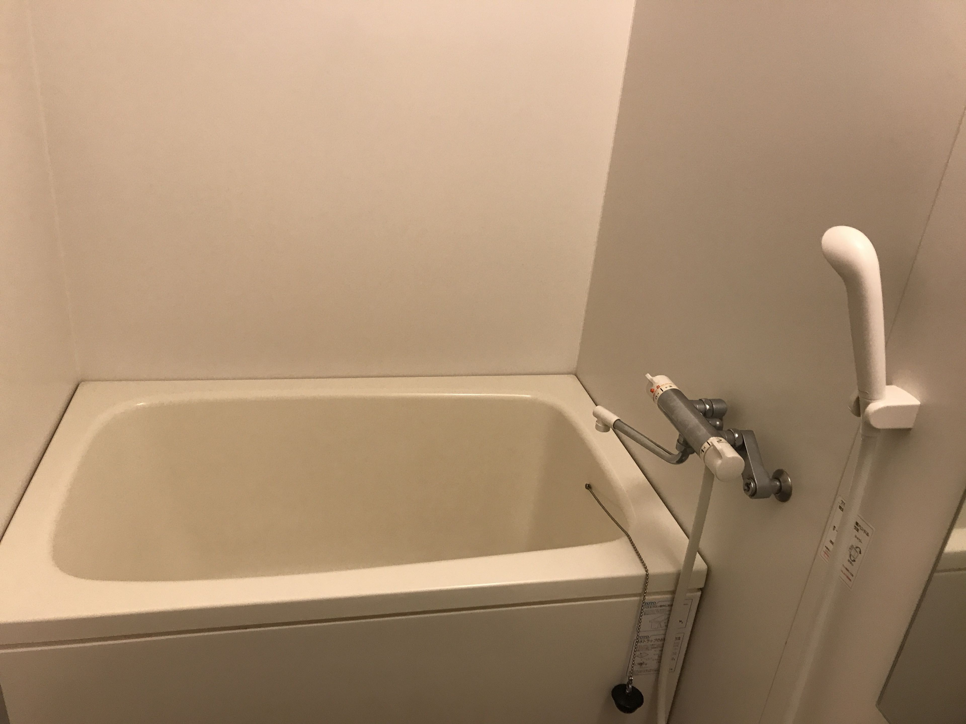 A bathtub with a showerhead and a faucet.