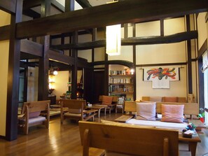 Une bibliothèque accueillante, avec des étagères en bois, des fauteuils confortables et une atmosphère chaleureuse.