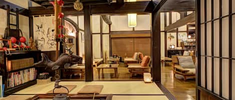 A traditional Japanese interior with tatami flooring, wooden furniture, and a tea ceremony setup.