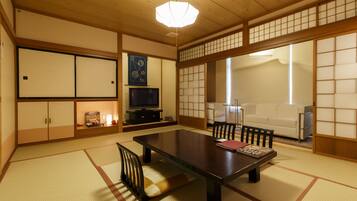 A traditional Japanese room with tatami flooring, a low table, and sliding doors.