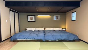 Quarto com uma cama grande, piso de madeira e teto com um respiradouro.