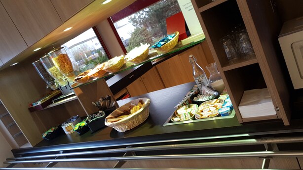 A buffet area with various food items and condiments.