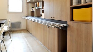 A modern kitchen with wooden cabinets, a built-in oven, and a window providing natural light.