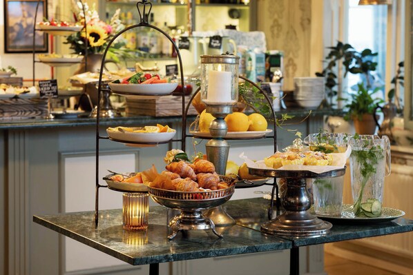 A buffet setup with various food items and a candle centerpiece. - Strandflickornas Havshotell (Lysekil)