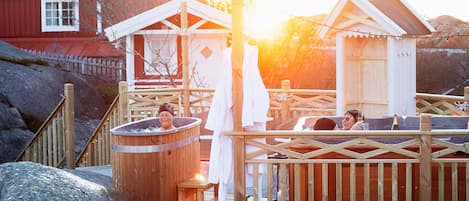A wooden deck with hot tubs and a wooden fence.