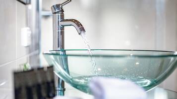 Une salle de bain moderne avec un lavabo en forme de bol en verre, un robinet et un porte-serviettes.