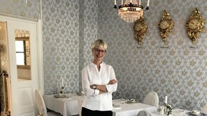 A dining room with a chandelier, ornate wall clocks, and a patterned carpet. - Annas Hotell (Kristianstad)