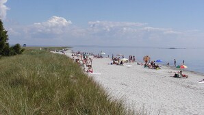 A beach with people sunbathing and swimming. - Annas Hotell (Kristianstad)