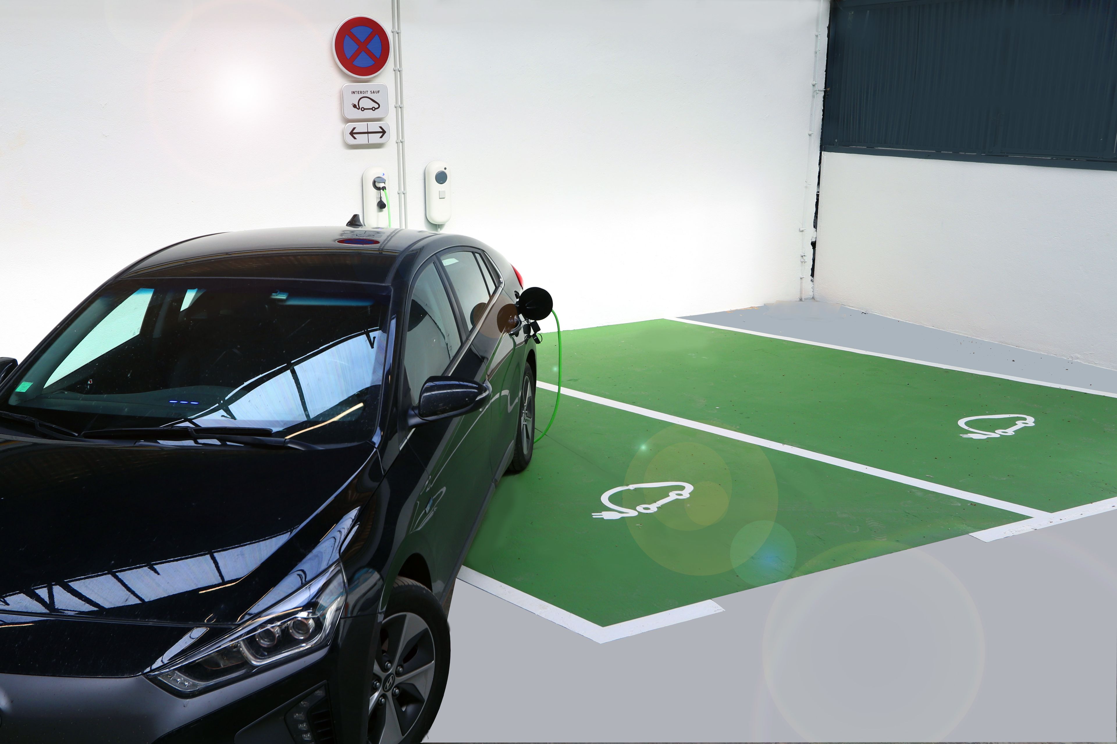 A parking space with a green floor and white parking lines.