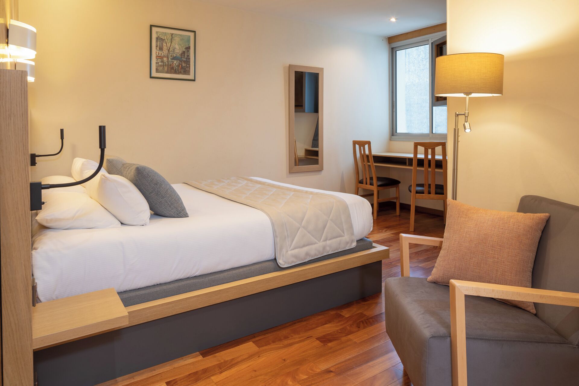 Une chambre moderne comprenant un lit, une table de chevet et un espace bureau avec une chaise.