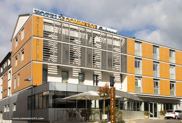 A hotel with a modern design, featuring a prominent sign for the hotel and a restaurant.