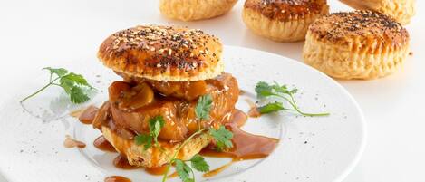 A plate with a sandwich and four pastries.