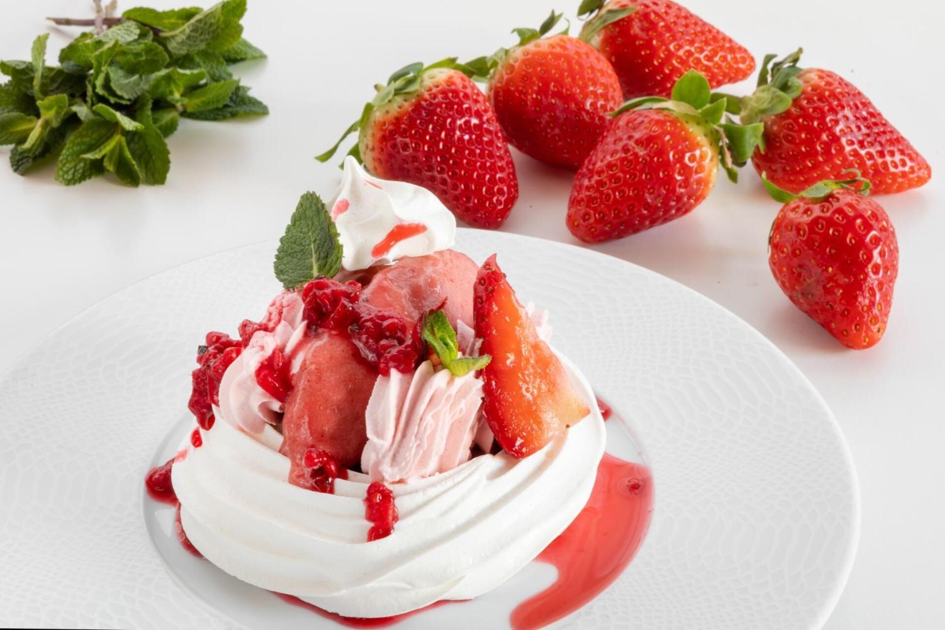 A dessert with strawberries and whipped cream on a plate.