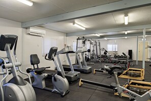 Een sportschool met loopbanden, elliptische trainers en gewichten.