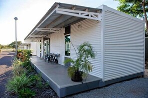 Een modern, gelijkvloers gebouw met een plat dak en een overdekte veranda.