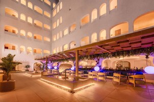 A spacious indoor area with multiple seating arrangements and a central water feature.