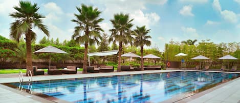 Una piscina al aire libre, sillones reclinables de piscina