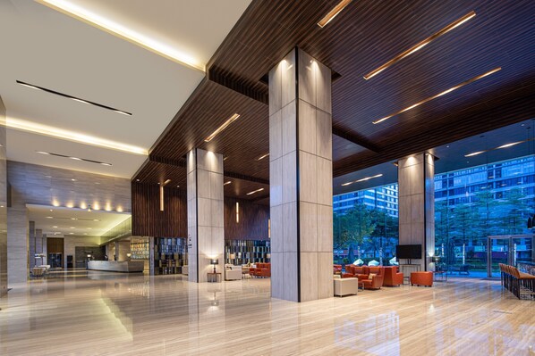 A spacious lobby with a reception desk, seating area, and large windows offering views of the outside. - Crowne Plaza Guangzhou Huadu by IHG (Guangzhou)