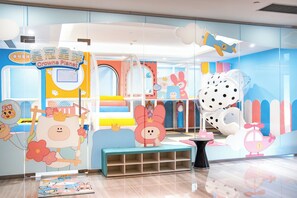 Un espace de jeux pour enfants agrémenté de décorations colorées et d’une structure de jeu.