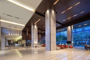 Un hall d’entrée spacieux, doté de hauts plafonds, de grandes colonnes et d’un design moderne.