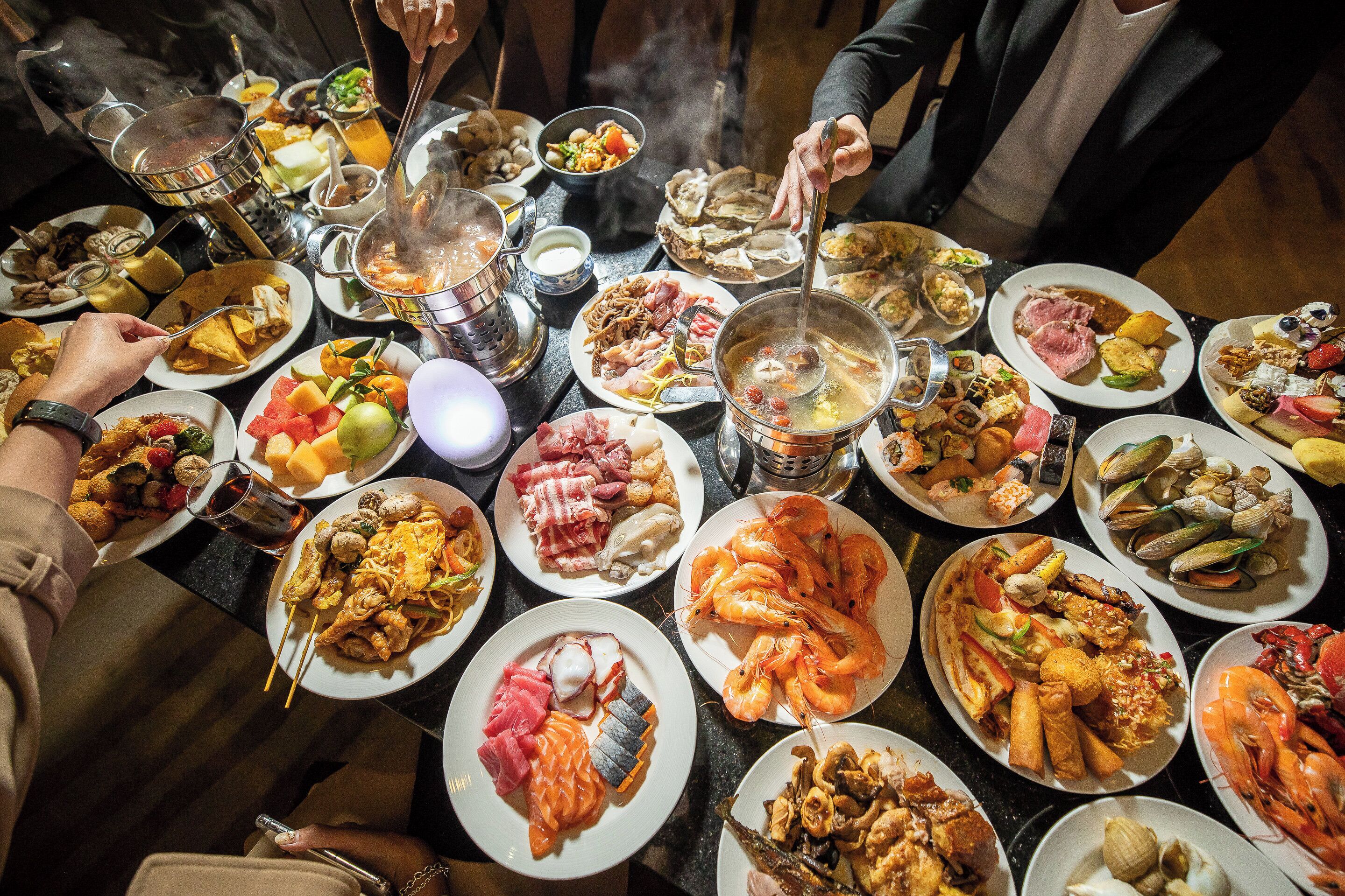 Una mesa con diferentes platos y una olla caliente.