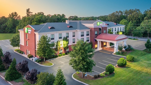 A hotel with a brick facade, a covered entrance, and a parking lot. - Holiday Inn Express Hotel & Suites Tullahoma by IHG (Tullahoma)