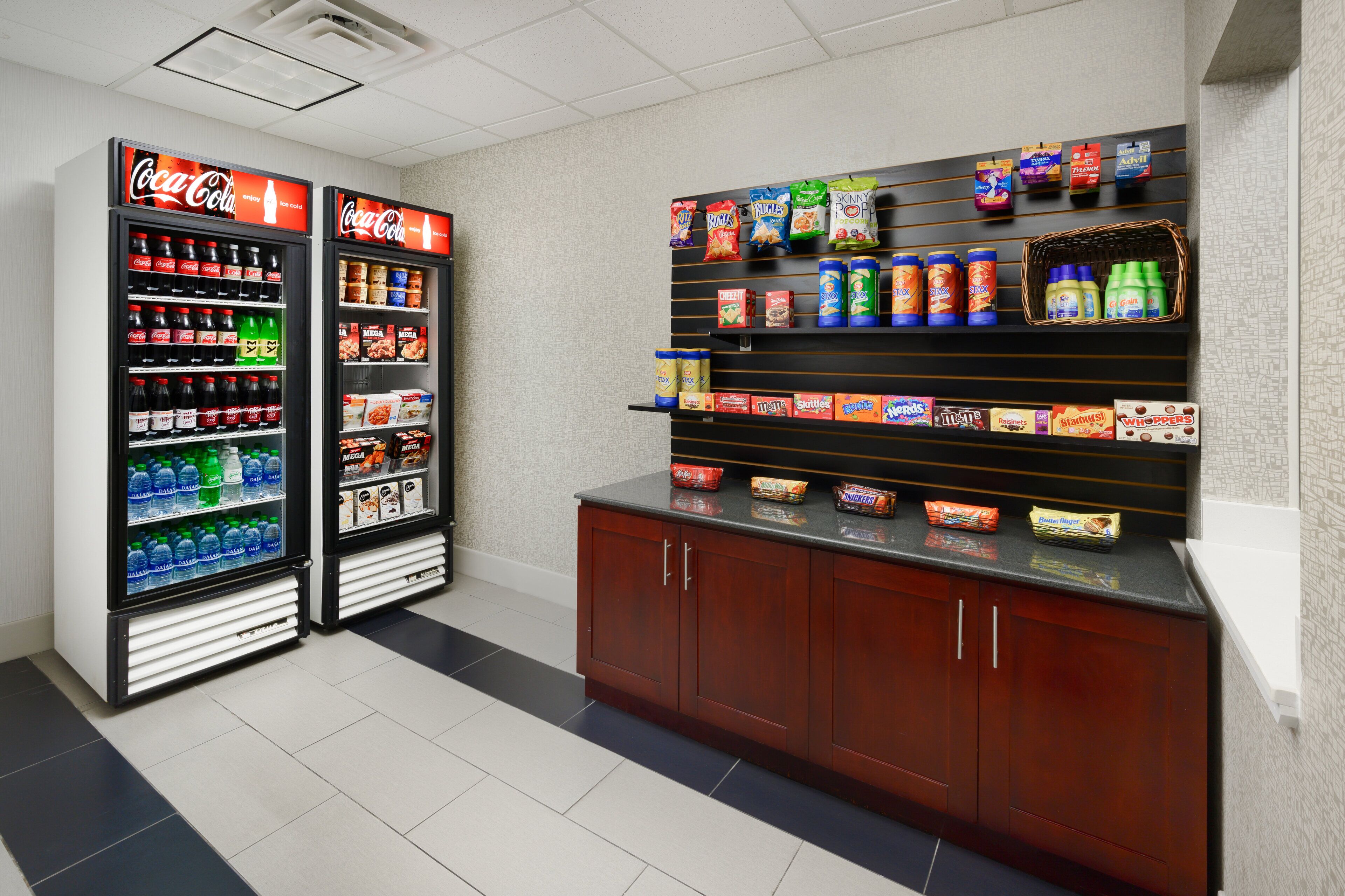 A vending area with Coca-Cola refrigerators and snack shelves.