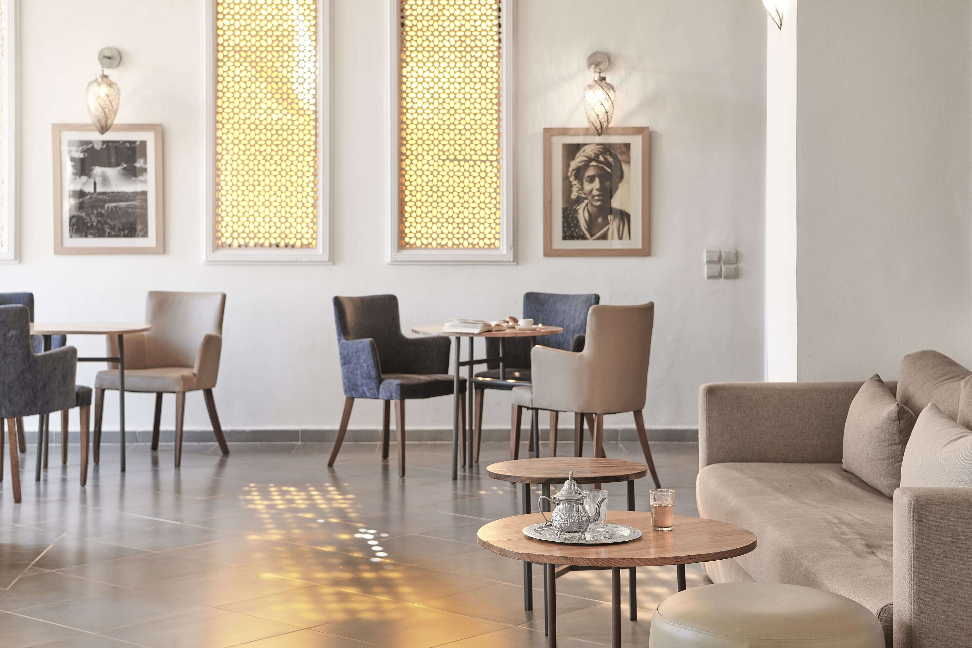 A modern interior with a sofa, chairs, and tables arranged in a lounge area.