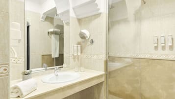 A modern bathroom with a large mirror, two sinks, and a glass shower enclosure.