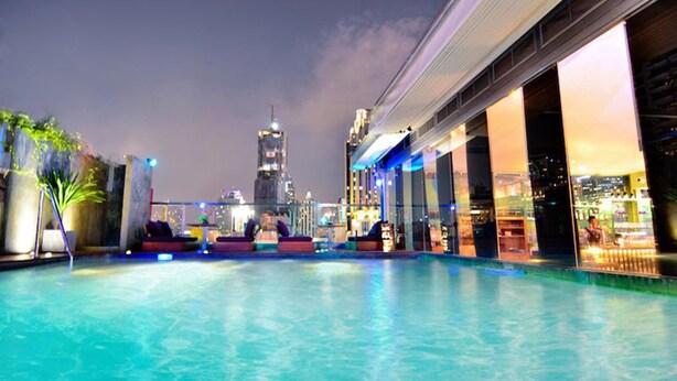 A rooftop pool with a city skyline view, lounge seating, and a bar area. - Galleria 10 Hotel Bangkok (Bangkok)