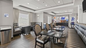 A modern hotel lobby with seating areas, a reception desk, and a view of the outside. - Holiday Inn Express & Suites Gonzales by IHG (Gonzales)