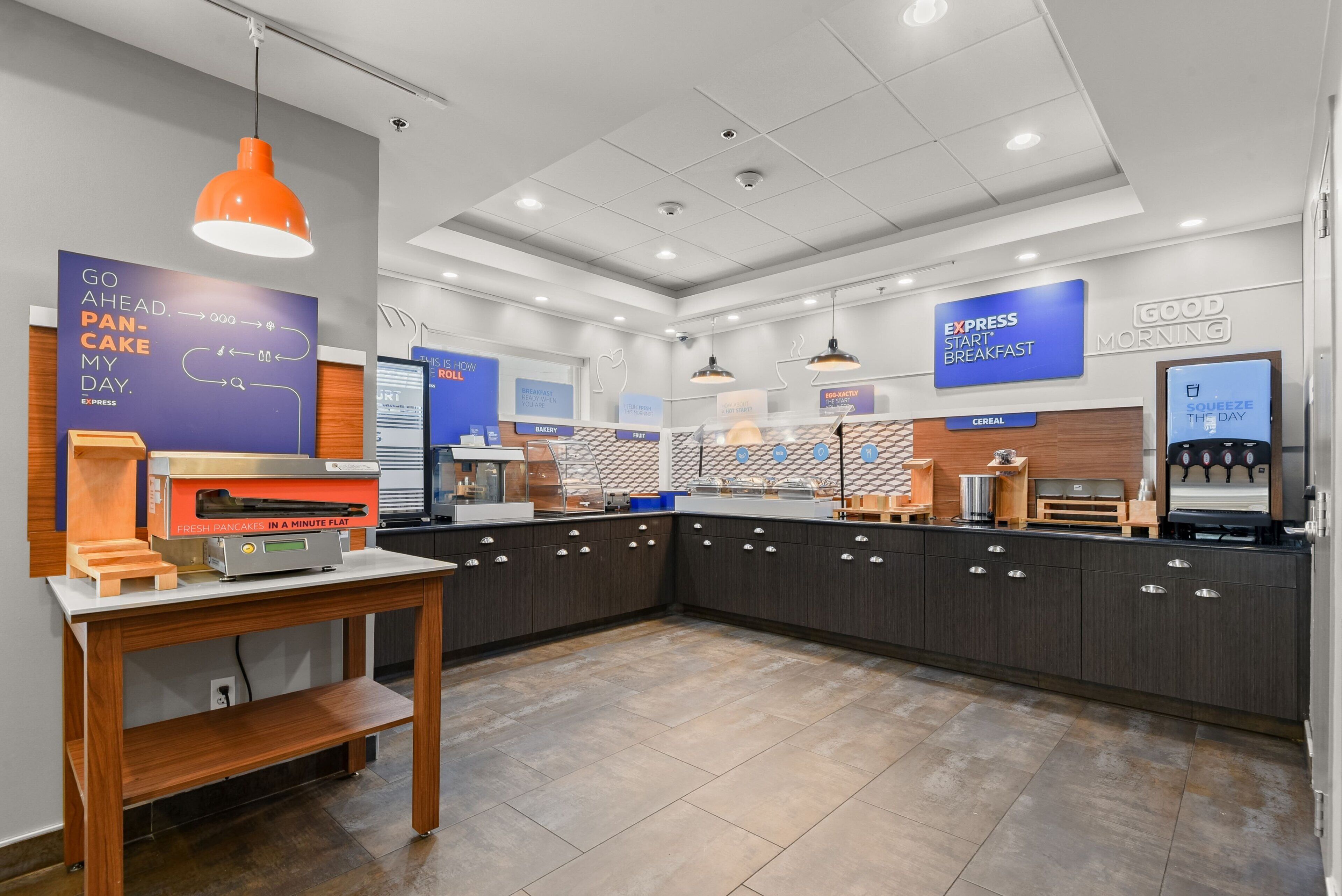 A modern kitchen area with a countertop, a coffee machine, and a sign that reads "EXPRESS START BREAKFAST".