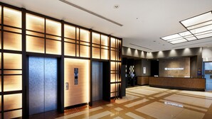 A modern hotel lobby with a reception desk, elevators, and a check-in counter. - Daiwa Roynet Hotel Kyoto Hachijoguchi (Kyoto)