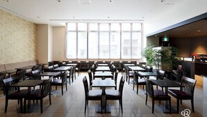 A spacious dining area with multiple tables and chairs, large windows, and a kitchen area. - Daiwa Roynet Hotel Kyoto Hachijoguchi (Kyoto)
